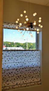 Genesis Top-down Roman Shade complements beautiful lighting at Frank Webb Bath